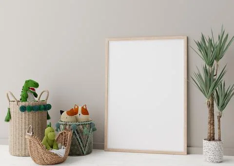 Empty vertical picture frame standing on the floor in modern child room. Mock Stock Photos