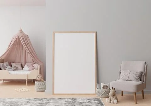 Empty vertical picture frame standing on the floor in modern child room. Mock Stock Photos