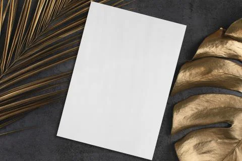 Empty vertical rectangle poster mockup with golden palm and monstera leaves o Stock Photos