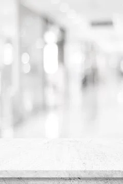 Empty vertical white cement table over white blur store background, product d Stock-Fotos