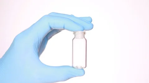 Empty vial in doctor's hand dressed in blue glove 動画素材 96985878