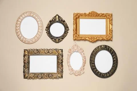 Empty vintage frames hanging on beige wall Stock Photos