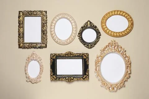 Empty vintage frames hanging on beige wall 스톡 사진