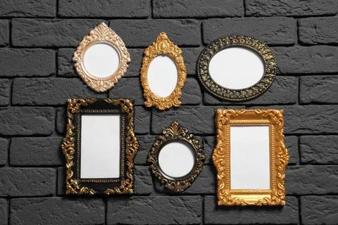 Empty vintage frames hanging on dark brick wall. Mockup for design Foto stock