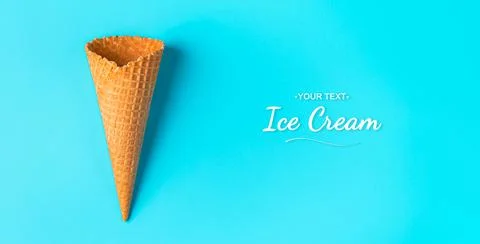 An empty waffle cone on a blue background with space to copy. Stock Photos