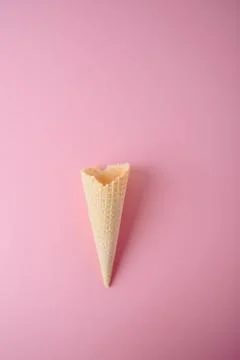 Empty waffle cone on a pink background close-up Stock Photos