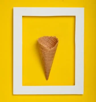 Empty waffle horn in white rectangular frame, top view, flat lay, minimalist  库存照片