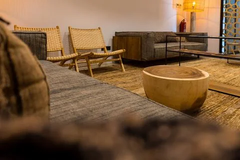Empty waiting room with sofa and wooden chairs illuminated with warm light .. Stock Photos