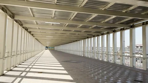 Empty walkway with strong leading lines and symmetrical metal framework Stock Footage 334491723
