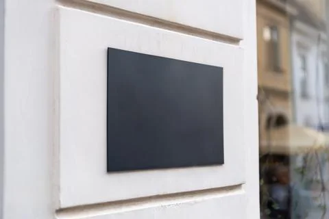 Empty wall mounted sign on a contemporary storefront facade, ideal for corp.. Stock Photos