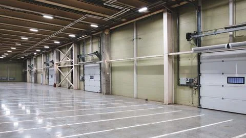 Empty warehouse interior features smooth concrete flooring with white lines.  Stock Photos