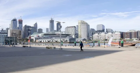Empty Waterfront and View to City with Solitary Figure Walking Stock Footage 129349432