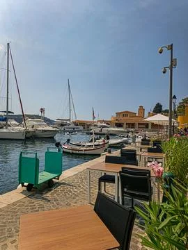 Empty waterfront cafe tables overlooking marina boats in Villefranche sur Mer 库存照片
