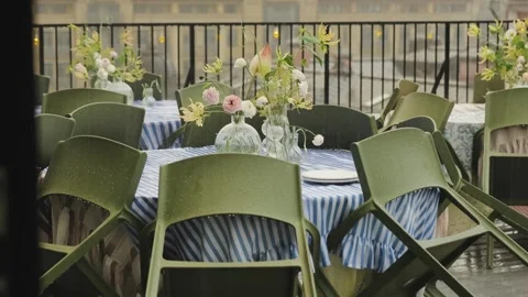 Empty wet tables decorated with flowers on the terrace of a restaurant in a cafe Stock Footage 318064044
