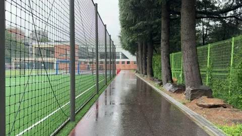Empty Wet Walkway Beside Soccer Field on Rainy Overcast Day 스톡 동영상 342801680