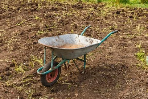 Empty wheelbarrow in the garden. Stock Photos