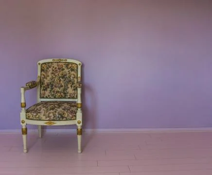 Empty white armchair standing in a empty room with pink laminate and purple s Stock Photos