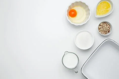 Empty white baking dish with ingredients for baking, including egg, milk, but Stock Photos