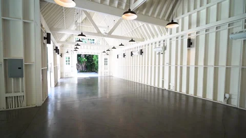 Empty white barn style interior with pendant lights and open doors Stock Footage 345684417