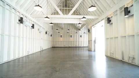 Empty white barn venue with vaulted ceiling and pendant lamps Stock Footage 345685808