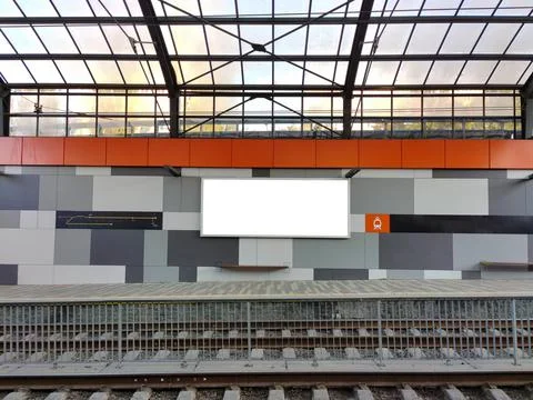 An empty white billboard hangs at an empty tram stop with a scrap for text Stock Photos