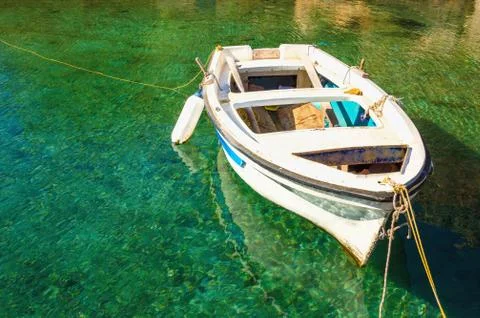Empty white boat floating in clear water Stock Photos
