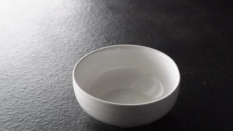 Empty white bowl moving in the light on dark background Stock Footage 338397214