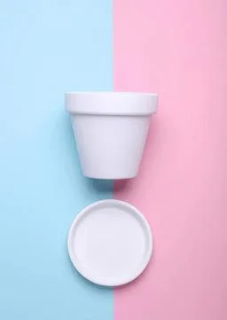 Empty white ceramic cup with lid on pastel pink and blue background Foto stock