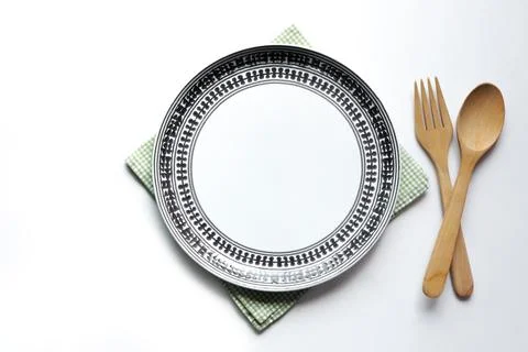 Empty white ceramic plate and wooden fork spoon on the table. Stock Photos