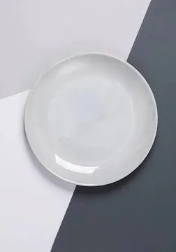 Empty white ceramic plate on a simple background Foto stock