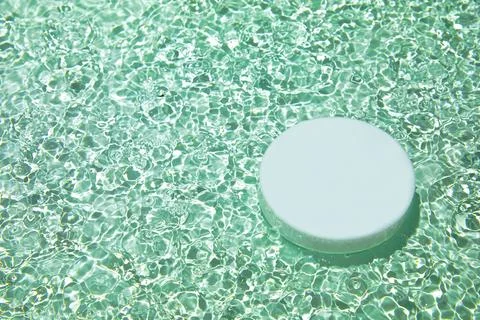Empty white circle podium on transparent green clear water background Stock Photos