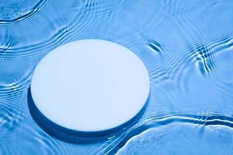 Empty white circle podium on transparent dark blue water background Stock Photos