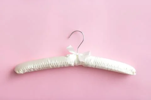 Empty white clothes hanger on a bright pink background with copy space Stock Photos