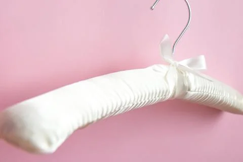 Empty white clothes hanger on a bright pink background with copy space Stock Photos