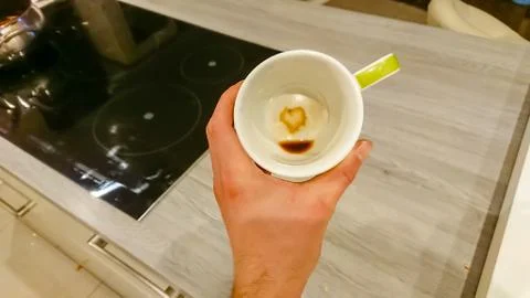 In an empty white coffee cup, coffee residues form a heart symbol Stock Photos