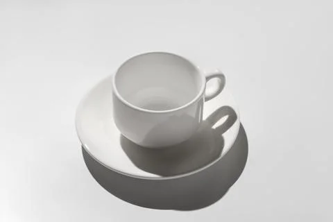 Empty white coffee cup. hard shadows on gray background 스톡 사진