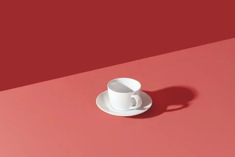 Empty white cup in bright light on a pink table. Coffee or tea cup minimalist on Stock Photos