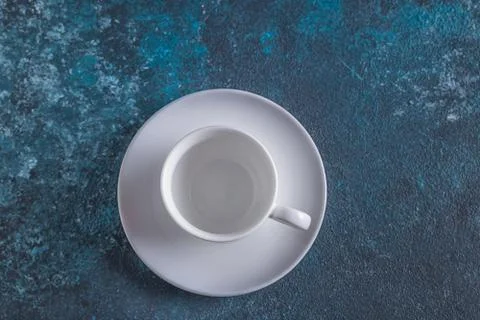 Empty white cup for coffee on blue background,flat lay, copy space. Stock Photos