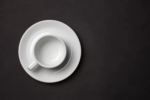 Empty white cup for espresso with saucer on black background. Stock Photos