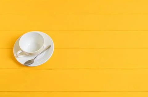 Empty White Cup with Spoon on Yellow Wooden Background Stock Photos