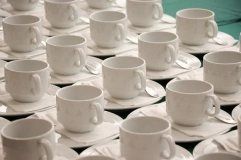 The empty white cups with spoons for coffee or hot tea put waiting guests Stock Photos