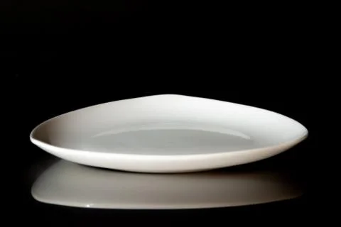 Empty white dinner plate on black background Stock Photos