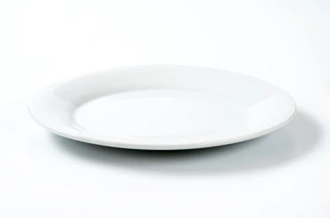 Empty white dinner plate with ribbed rim Stock Photos