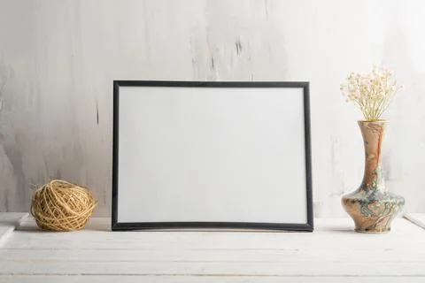 Empty white frame with flower on wall background. The concept of design and f Stock Photos