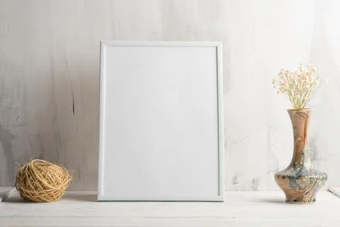 Empty white frame with flower on wall background. The concept of design and f Stock Photos