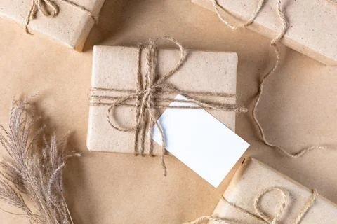 Empty white gift tag mock up on craft paper box with dried spikelets decorati Foto stock