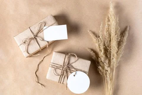 Empty white gift tag mock up on craft paper box with dried spikelets decorati Stock Photos