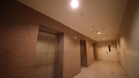 Empty white hall with metal elevator doors in modern building in residential Stock Footage 276362674