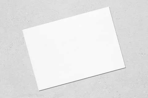 Empty white horizontal rectangle poster mockup lying diagonally on grey concr Stock Photos