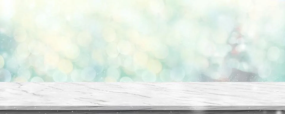 Empty white marble table with abstract blur green christmas tree and snow fal Stock Photos
